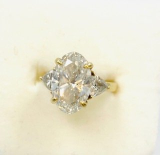 5.02 CtTW- 4 Ct -Elongated Oval Diamond Center with 2-.5 Ct Trillion Side Stones set in 18kt Gold